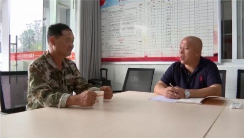 杜雅军（右）在与种植大户对接水稻管护相关事宜。刘奕麟摄